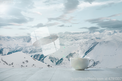 Image of Single tea or coffee mug and landscape of mountains on background