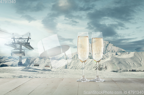 Image of Champagne in glasses and landscape of mountains on background