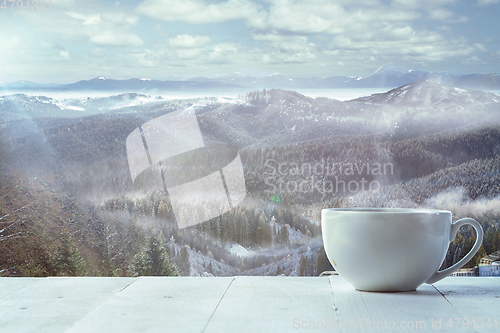 Image of Single tea or coffee mug and landscape of mountains on background