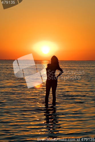 Image of Silhouette of the young woman on a gulf on a sunset