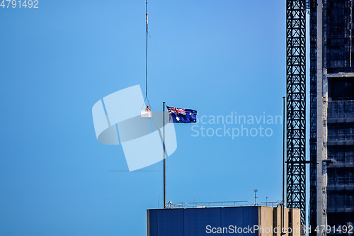 Image of construction worker in a crane gondola near the Australia flag