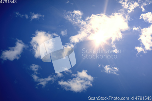 Image of typical blue sky with sun and clouds background