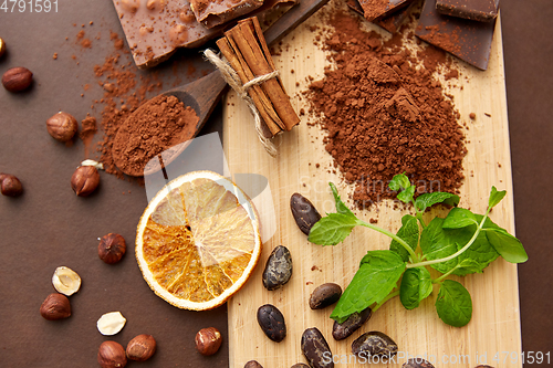 Image of chocolate with hazelnuts, cocoa beans and powder