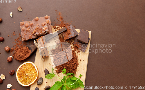 Image of chocolate with hazelnuts, cocoa beans and powder