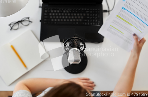 Image of woman with microphone recording podcast at studio