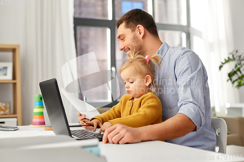 Image of working father with baby daughter at home office