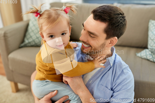 Image of father with little baby daughter at home