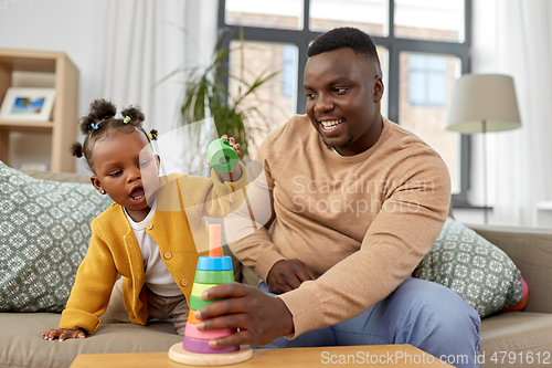 Image of african family playing with baby daughter at home