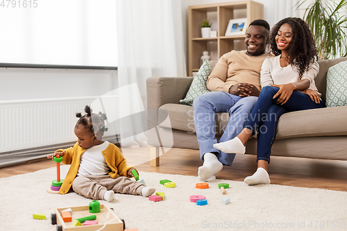 Image of african family with baby daughter playing at home