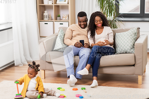 Image of african baby girl playing with toy blocks at home