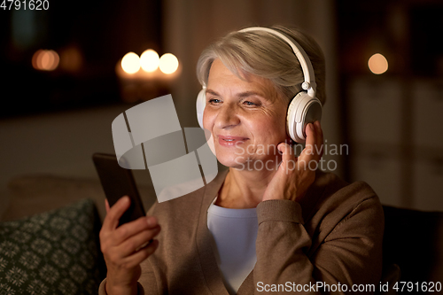 Image of senior woman in headphones listening to music