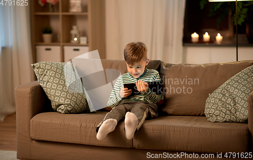 Image of happy little boy with tablet computer at home