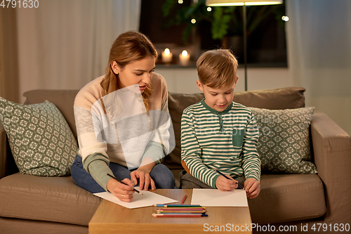 Image of mother and son with pencils drawing at home