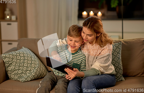 Image of mother and son using tablet computer at home