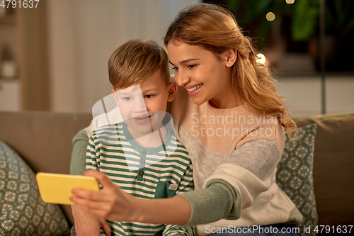 Image of mother and son taking selfie by smartphone at home