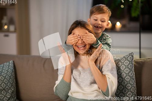 Image of happy smiling mother playing with her son at home