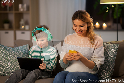 Image of mother and son using gadgets at home