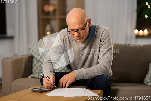 Image of senior man with bills and calculator at home