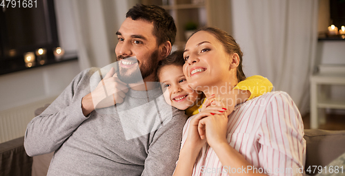 Image of portrait of happy family sitting on sofa at home