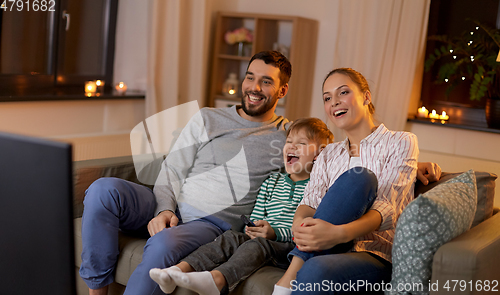 Image of happy family watching tv at home at night