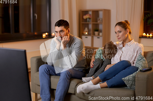 Image of family watching something boring on tv at night