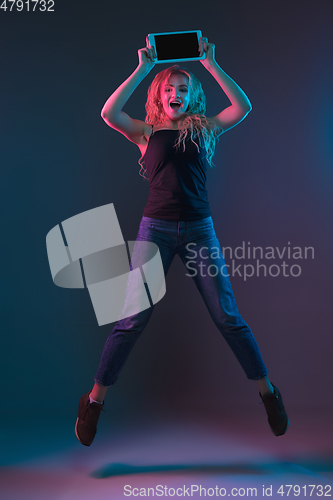 Image of Caucasian young woman\'s portrait on gradient background in neon light