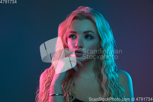 Image of Caucasian young woman\'s portrait on gradient background in neon light