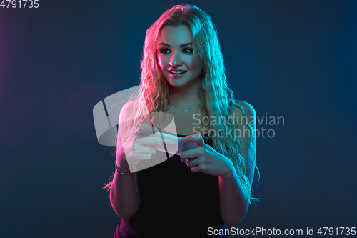 Image of Caucasian young woman\'s portrait on gradient background in neon light