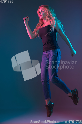 Image of Caucasian young woman\'s portrait on gradient background in neon light