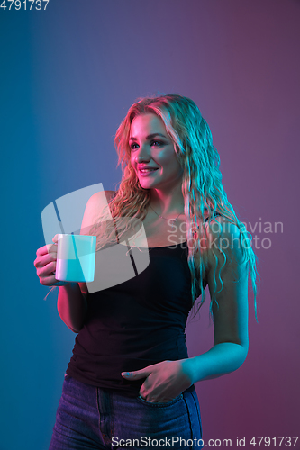 Image of Caucasian young woman\'s portrait on gradient background in neon light