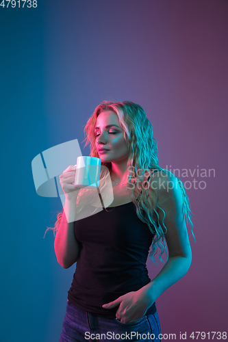 Image of Caucasian young woman\'s portrait on gradient background in neon light