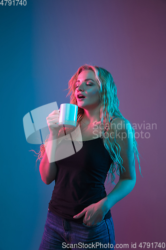 Image of Caucasian young woman\'s portrait on gradient background in neon light