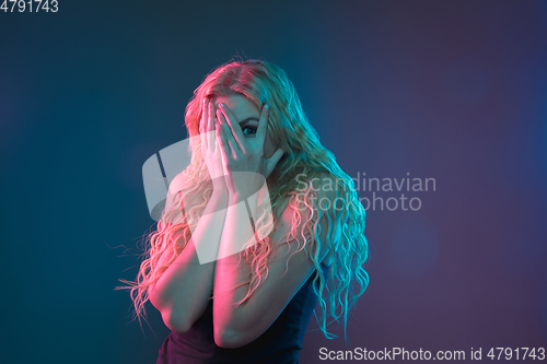 Image of Caucasian young woman\'s portrait on gradient background in neon light