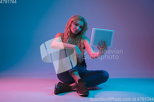 Image of Caucasian young woman\'s portrait on gradient background in neon light