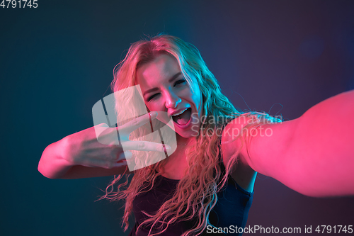 Image of Caucasian young woman\'s portrait on gradient background in neon light