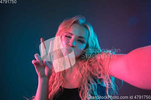 Image of Caucasian young woman\'s portrait on gradient background in neon light