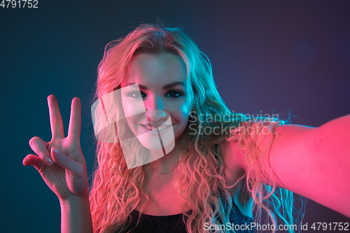 Image of Caucasian young woman\'s portrait on gradient background in neon light