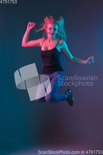Image of Caucasian young woman\'s portrait on gradient background in neon light