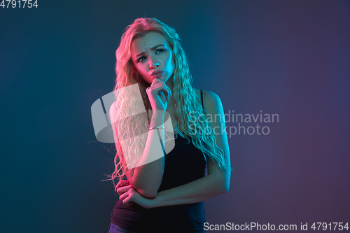 Image of Caucasian young woman\'s portrait on gradient background in neon light