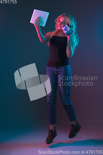 Image of Caucasian young woman\'s portrait on gradient background in neon light