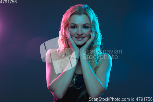 Image of Caucasian young woman\'s portrait on gradient background in neon light