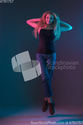 Image of Caucasian young woman\'s portrait on gradient background in neon light