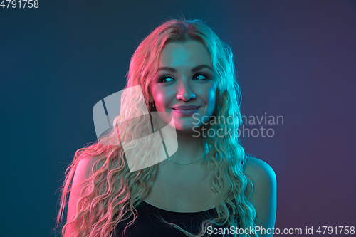 Image of Caucasian young woman\'s portrait on gradient background in neon light