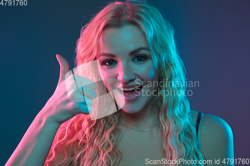 Image of Caucasian young woman\'s portrait on gradient background in neon light