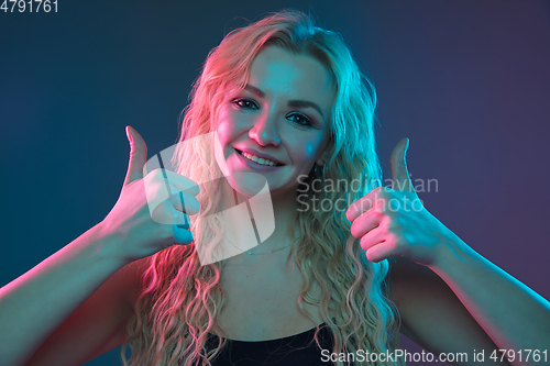 Image of Caucasian young woman\'s portrait on gradient background in neon light