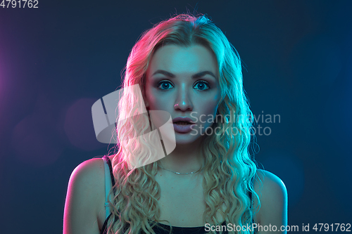 Image of Caucasian young woman\'s portrait on gradient background in neon light