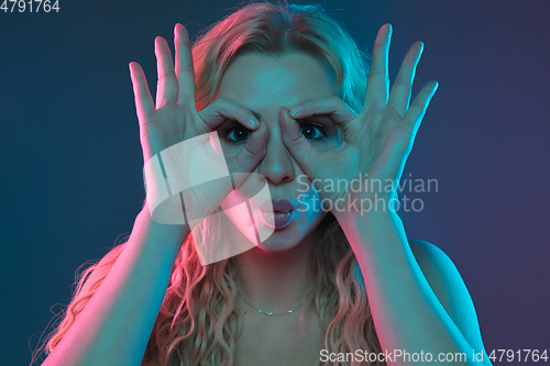 Image of Caucasian young woman\'s portrait on gradient background in neon light