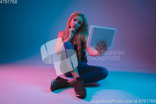 Image of Caucasian young woman\'s portrait on gradient background in neon light