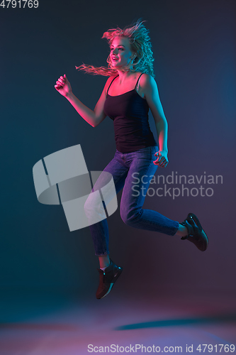 Image of Caucasian young woman\'s portrait on gradient background in neon light