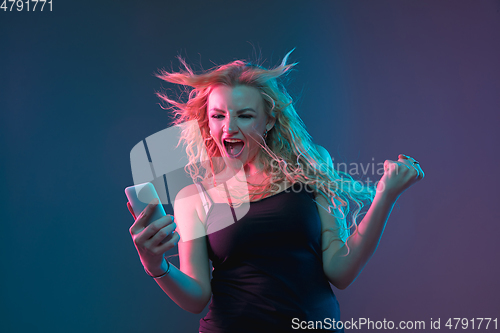Image of Caucasian young woman\'s portrait on gradient background in neon light
